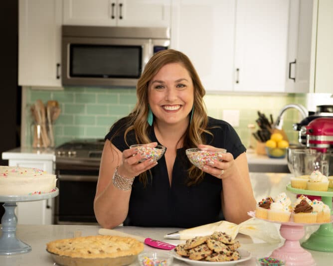 woman in kitchen holding bowls of sprinkles