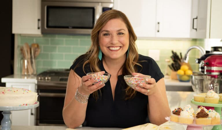 woman in kitchen holding bowls of sprinkles