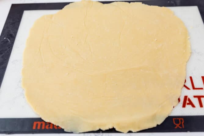 Pie crust rolled out onto a silicon baking mat