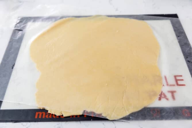 Second pie crust dough rolled out onto a silicon baking mat