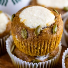 Close up of pumpkin cream cheese muffins stacked on top of eachother