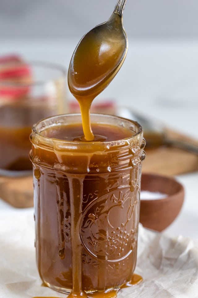 Spoonful of salted caramel sauce coming out of mason jar