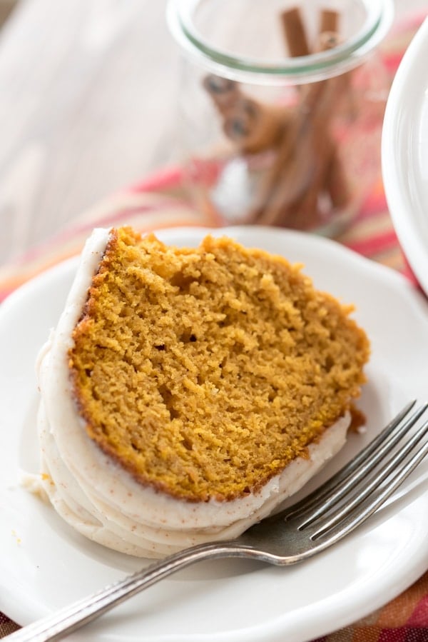 One slice of pumpkin bundt cake on a white plate with silver fork