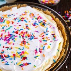 Overhead shot of funfetti pie with rainbow sprinkles on wood table