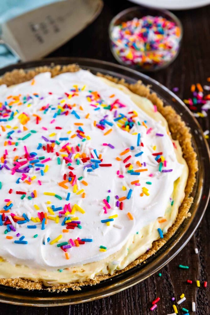 Overhead shot of funfetti pie with rainbow sprinkles on wood table