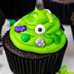 chocolate cupcake with green frosting with spooky sprinkles to look like cauldrons