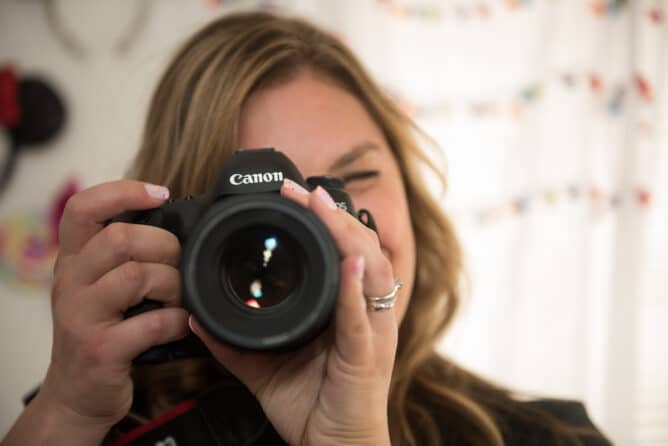 woman taking photo of photographer with canon camera