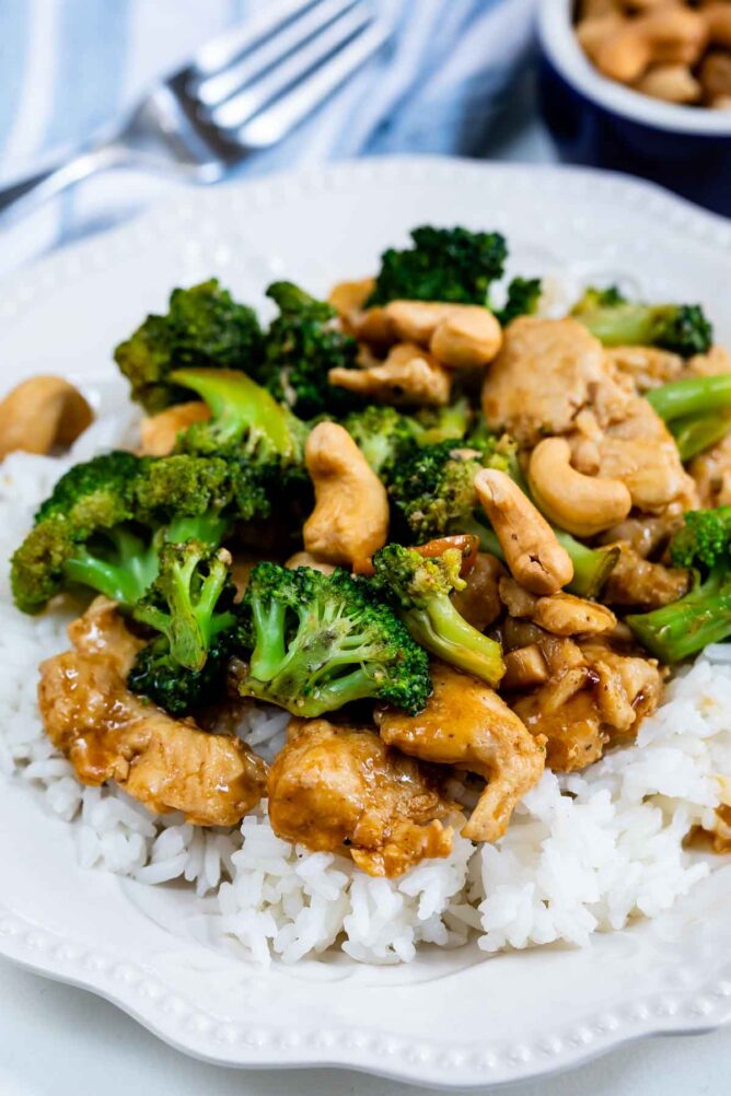 cashew chicken stir fry on bed of white rice on white plate