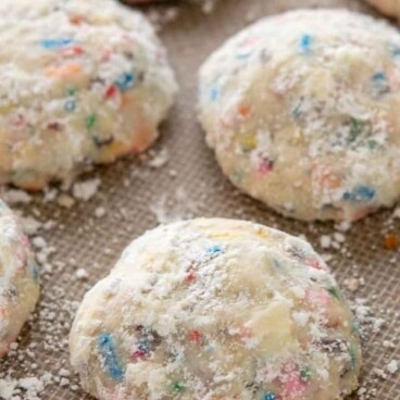 Overhead view of funfetti wedding cookies on a baking mat with recipe title on top of image