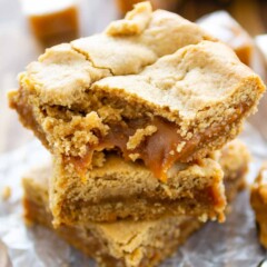 Stack of peanut butter caramel bars with bite taken out of top bar