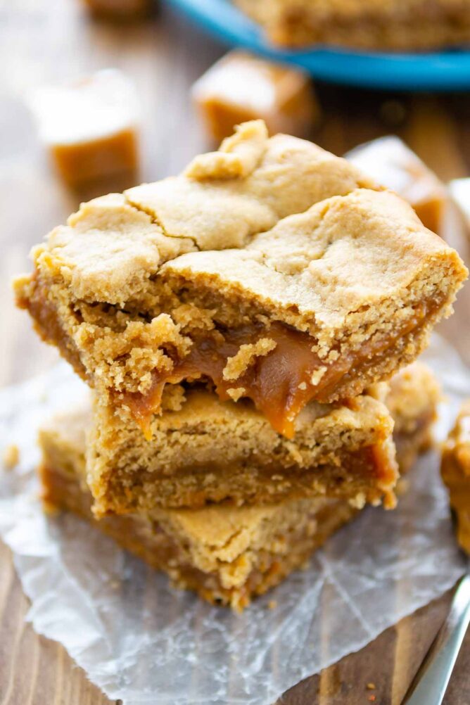 Stack of peanut butter caramel bars with bite taken out of top bar