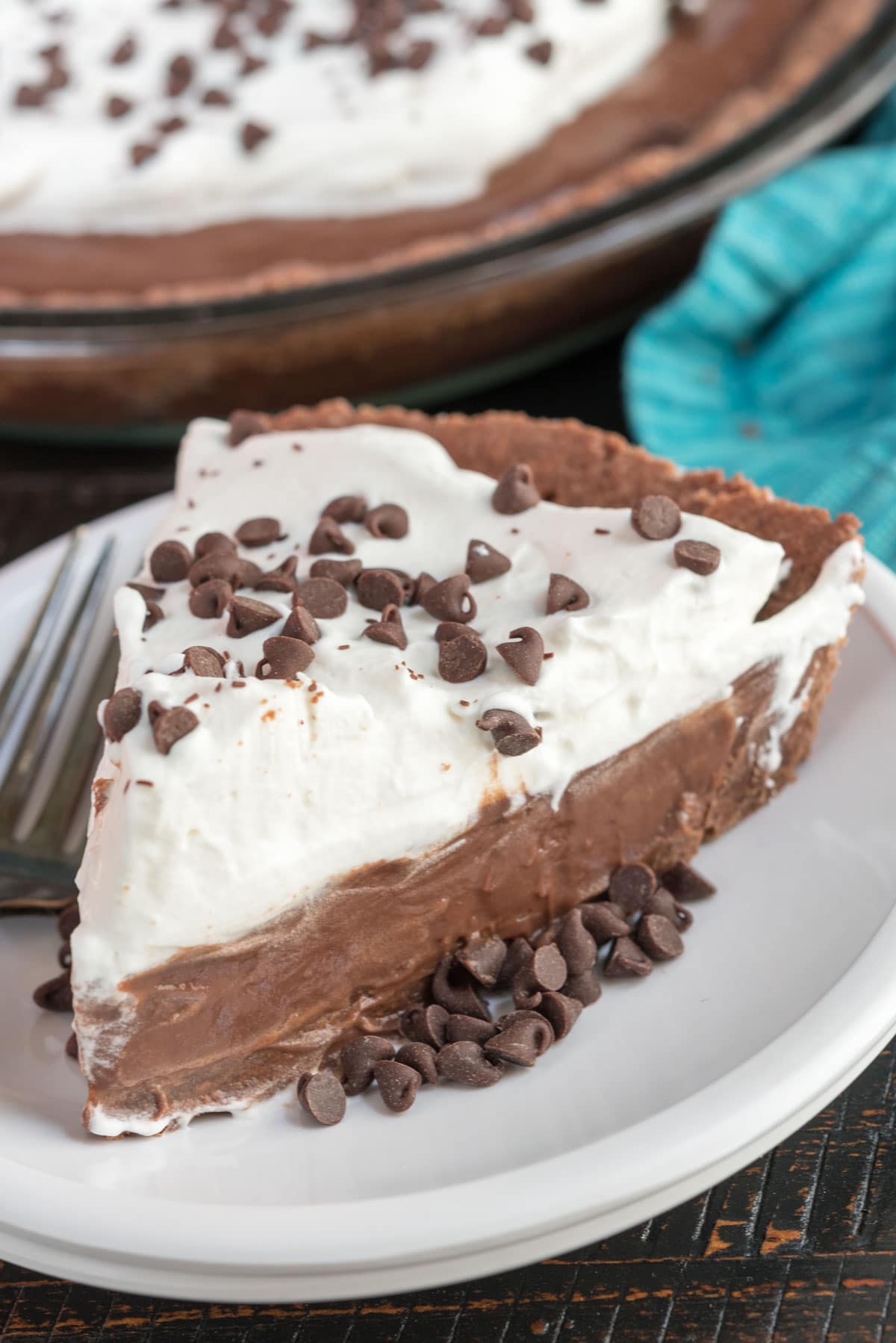 slice of chocolate pie with whipped cream on white plate