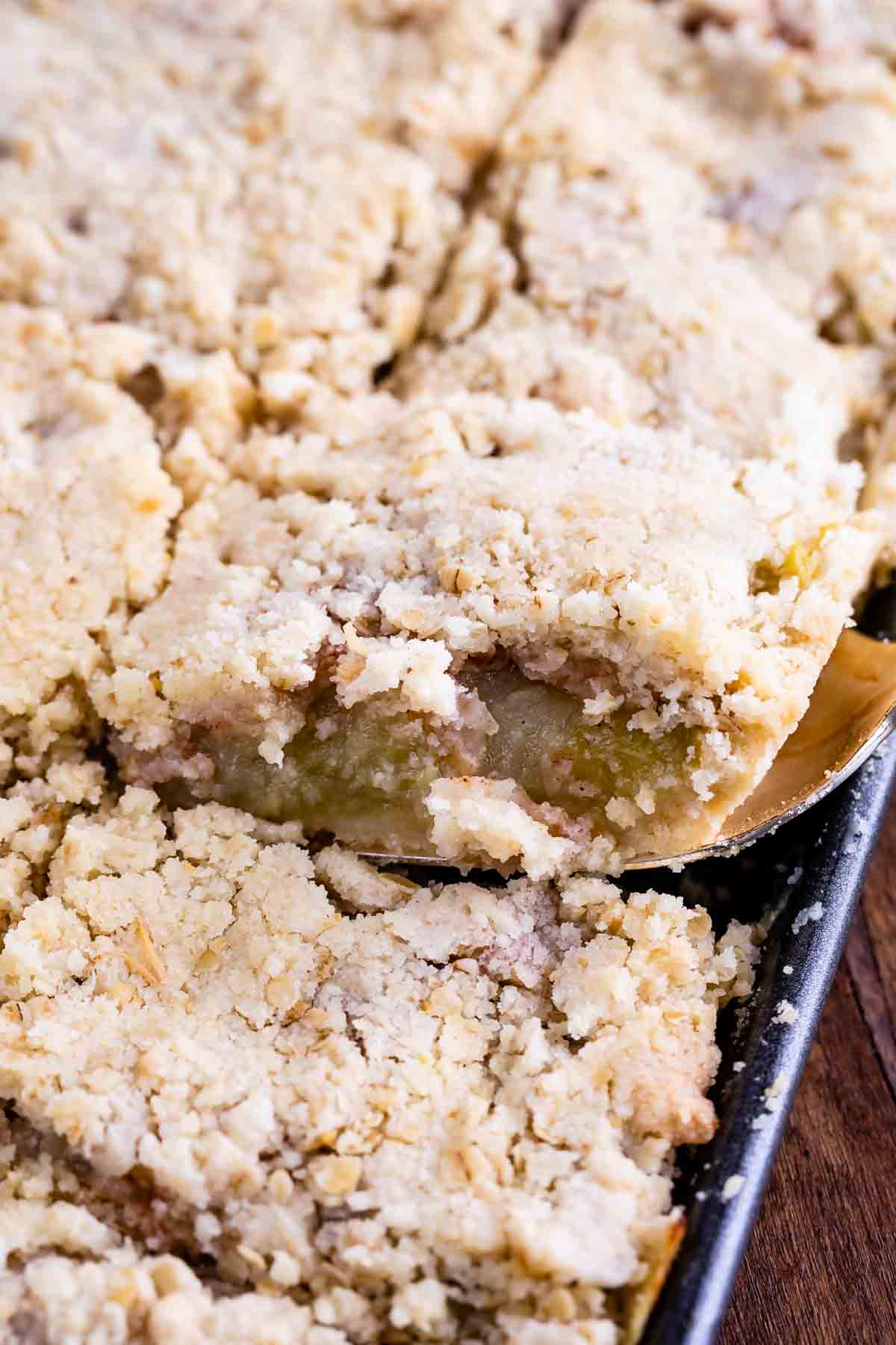 sliced apple slab pie in sheet pan with spatula