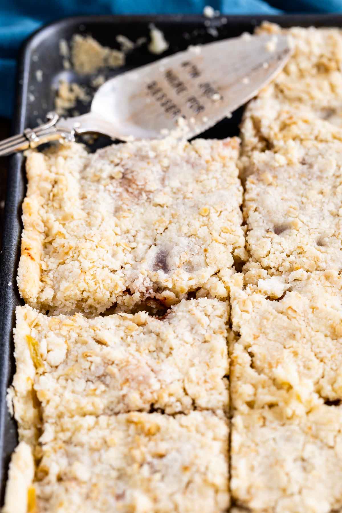 sliced apple slab pie in sheet pan with spatula