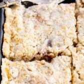 sliced apple slab pie in sheet pan with spatula and words on photo