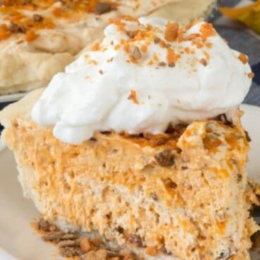 Slice of butterfinger pie on a white and blue plate with rest of pie in background and recipe title on top of image