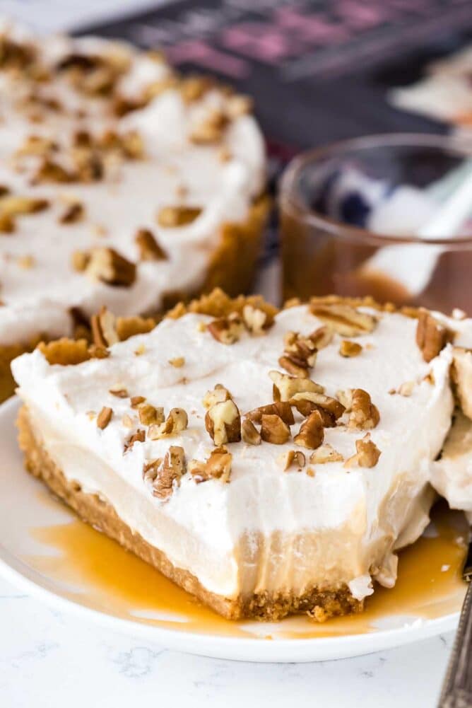 Slice of butterscotch pie on a plate with one bite missing