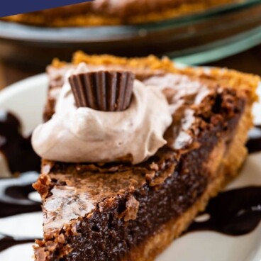 slice of chocolate pie with graham crust on white plate with hot fudge