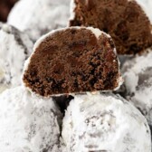 snowball cookies stacked in blue bowl with one cut open to show the inside with words on photo