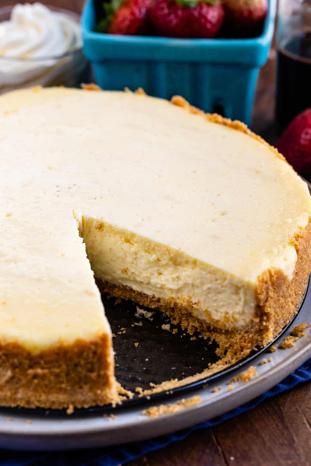 Overhead shot of classic cheesecake with one slice missing