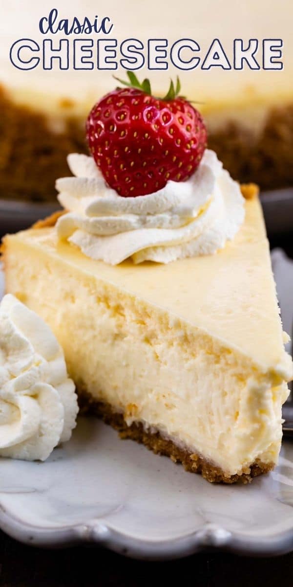 A slice of classic cheesecake on a plate with whipped cream and a strawberry on top and recipe title on top of image