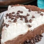 slice of chocolate pie with whipped cream on white plate with words on photo