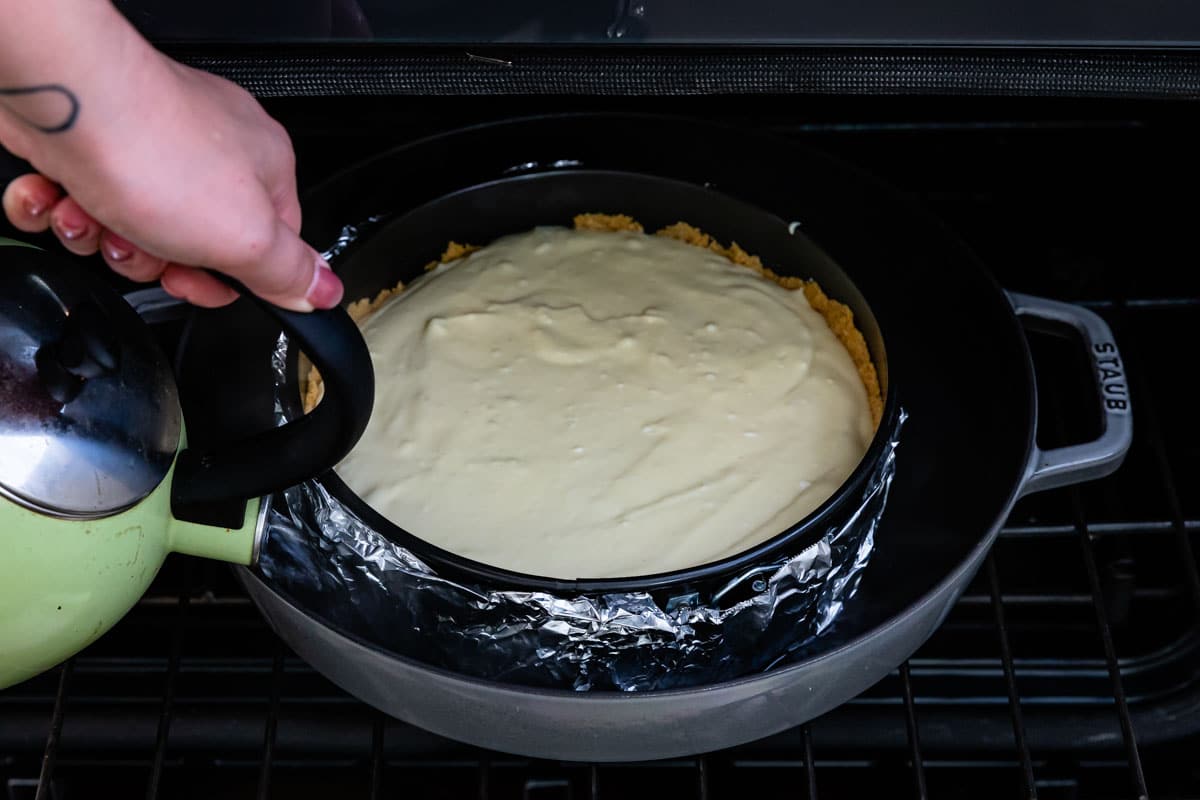 pouring water into a water bath in the oven