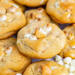 White chocolate macadamia nut cookies with white chocolate chips around