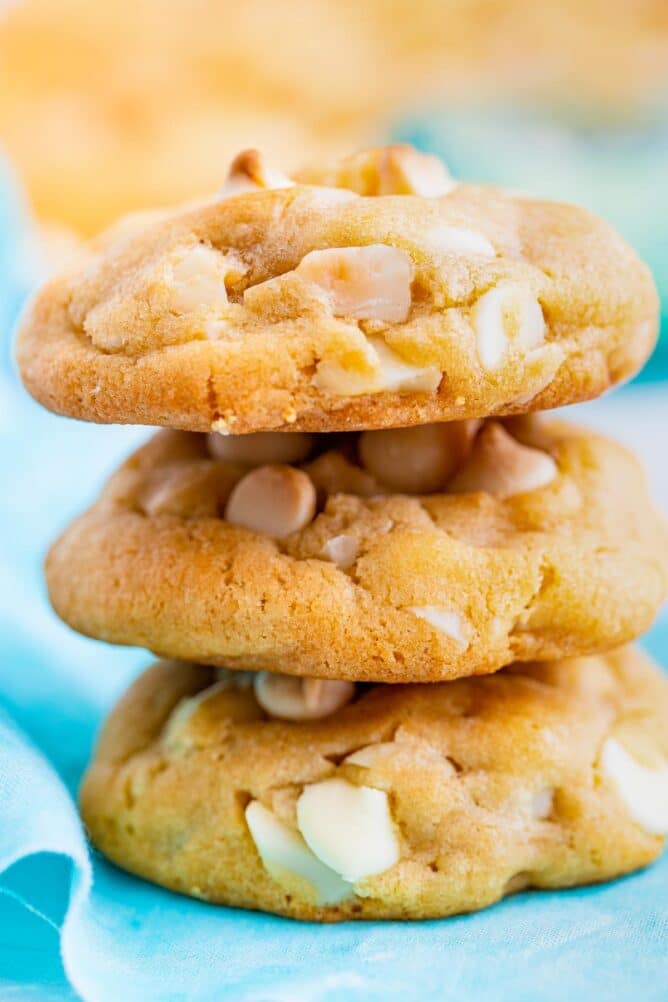 Side shot of white chocolate macadamia nut cookies stacked on top of eachother