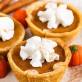 Three mini pumpkin pies with whipped cream on top
