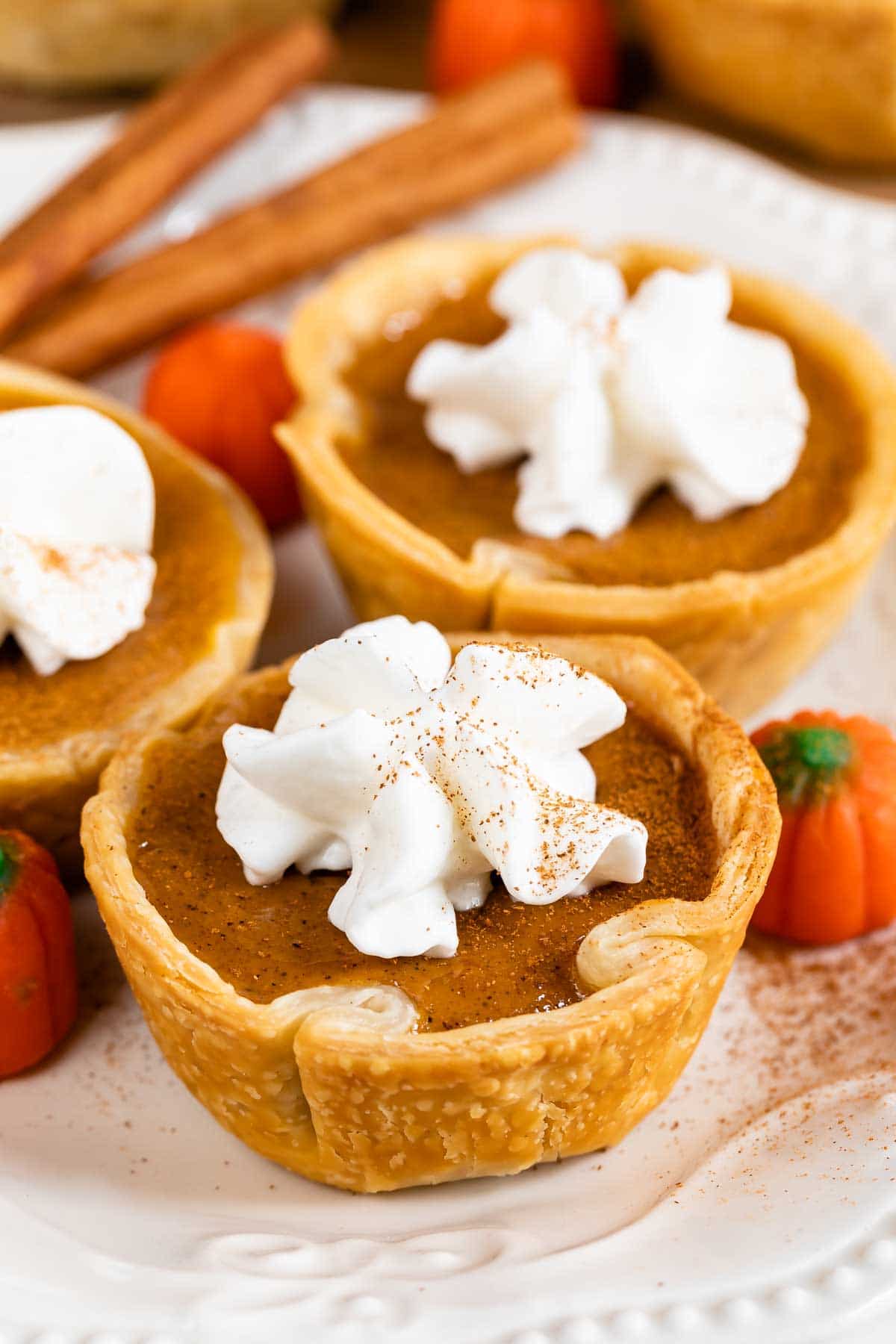 Three mini pumpkin pies with whipped cream on top