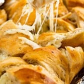 hand pulling cheesy pull apart bread with words on photo