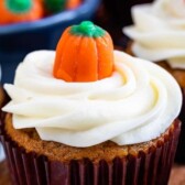Close up of pumpkin cupcake with pumpkin candy on top and recipe title on top of photo