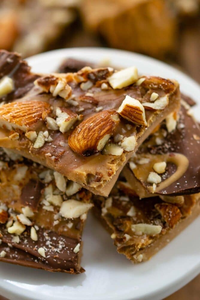 Close up of toffee pieces stacked on a white serving plate