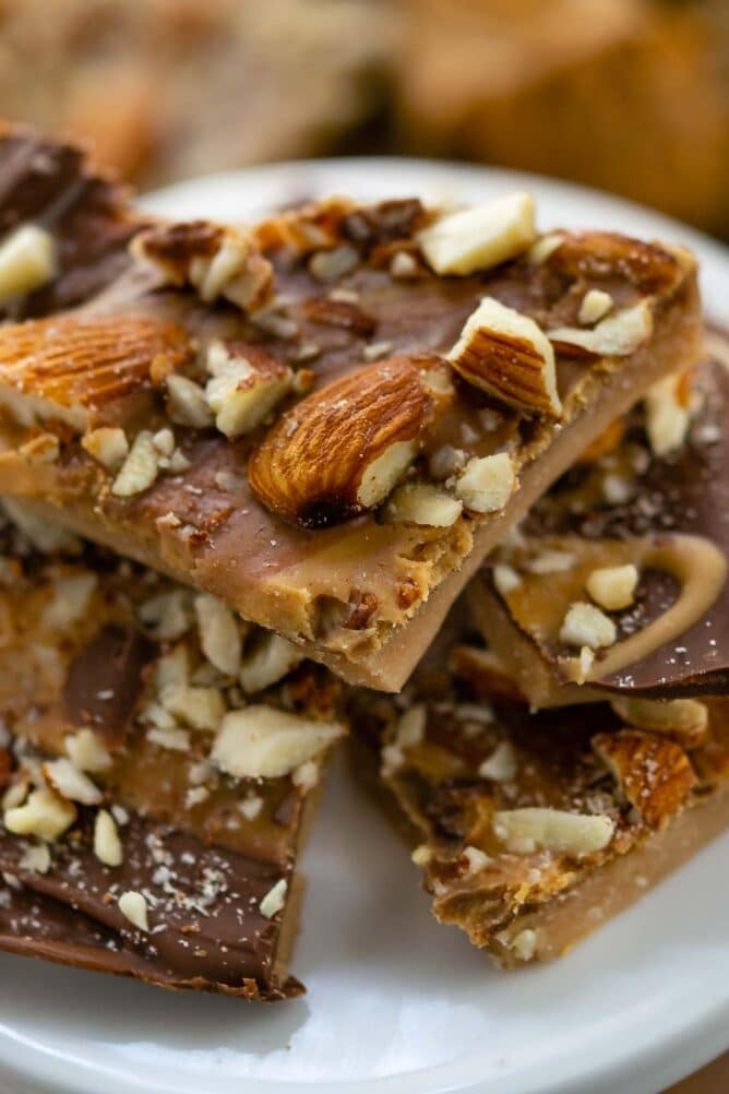 Close up of toffee pieces stacked on a white serving plate