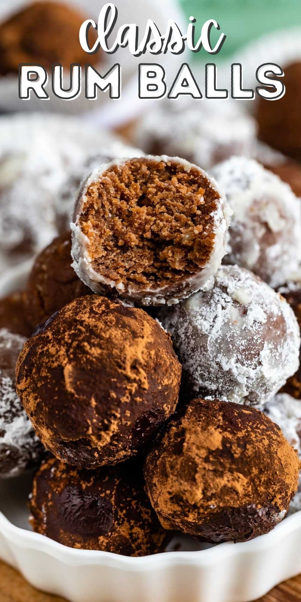 Easy rum balls stacked in a white dish with top one cut in half to show inside