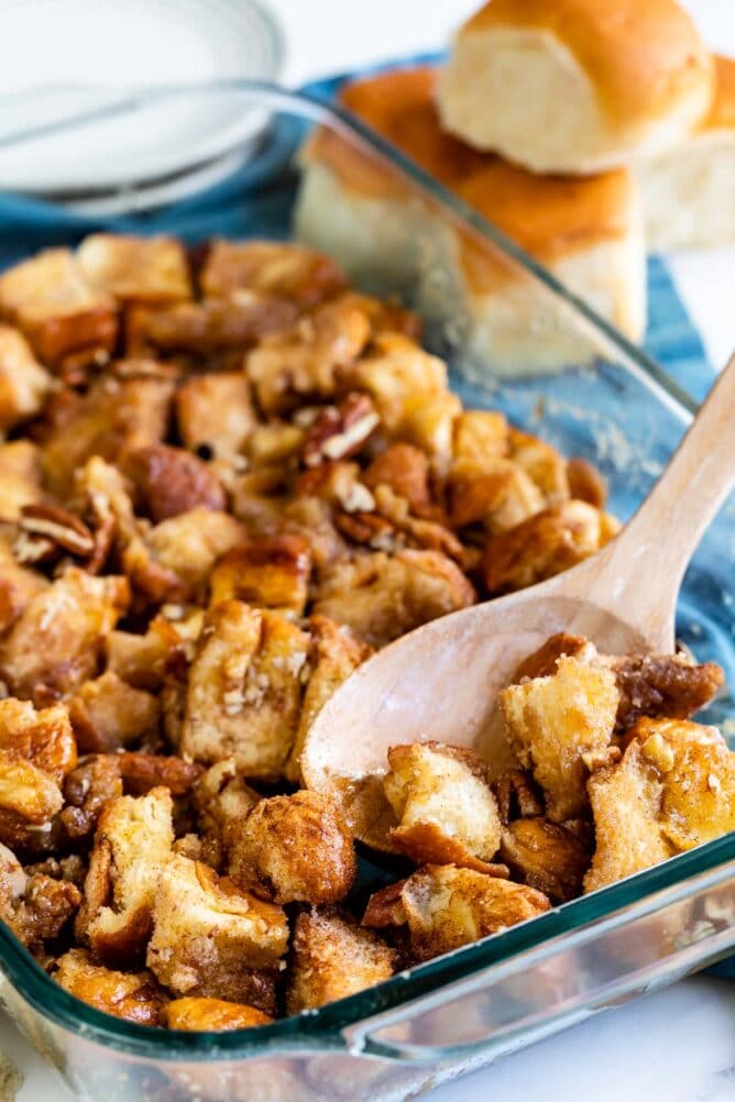 Monkey Bread in a glass baking dish with wooden spoon scooping some out
