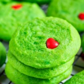 Stacks of green grinch cookies on a metal wire rack