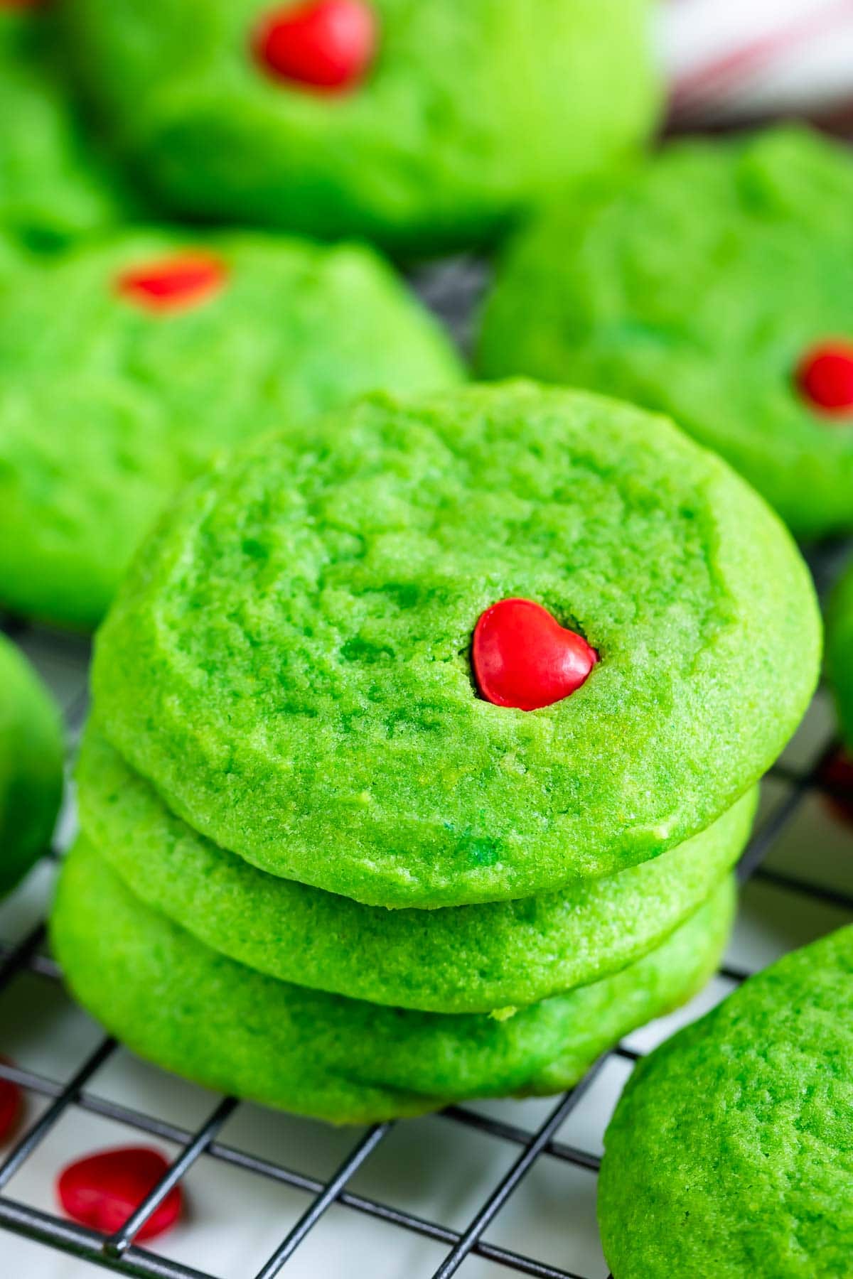 Stacks of green grinch cookies on a metal wire rack