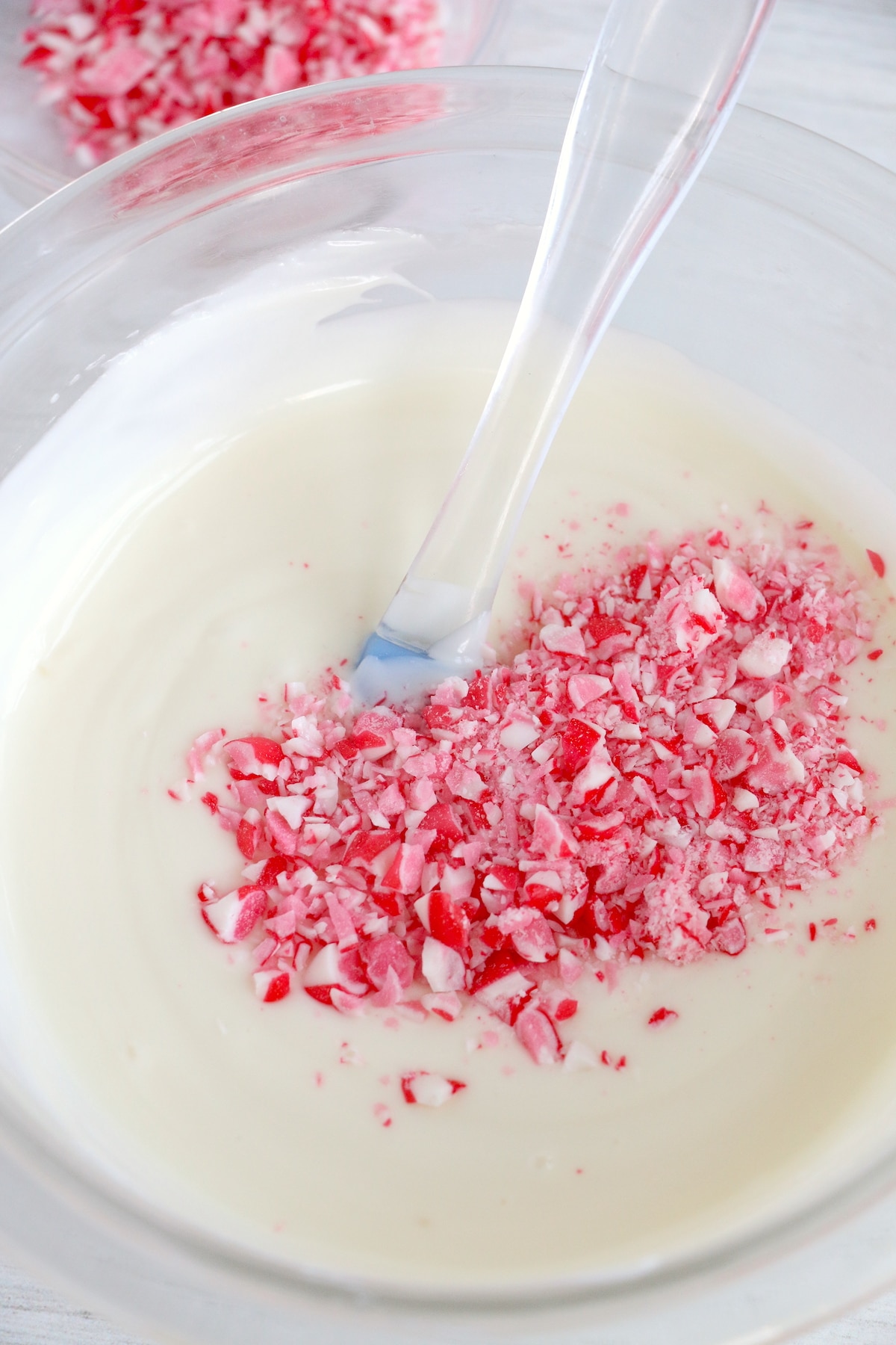 Overhead shot of candy cane pieces being stirred into white chocolate