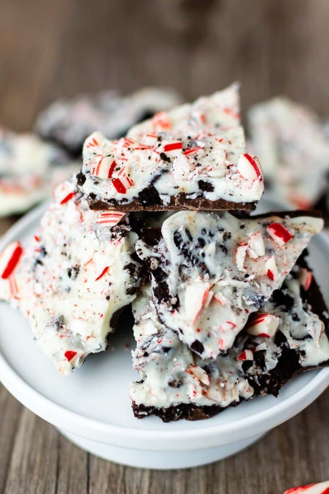 Close up of Oreo peppermint bark pieces on a white cake stand