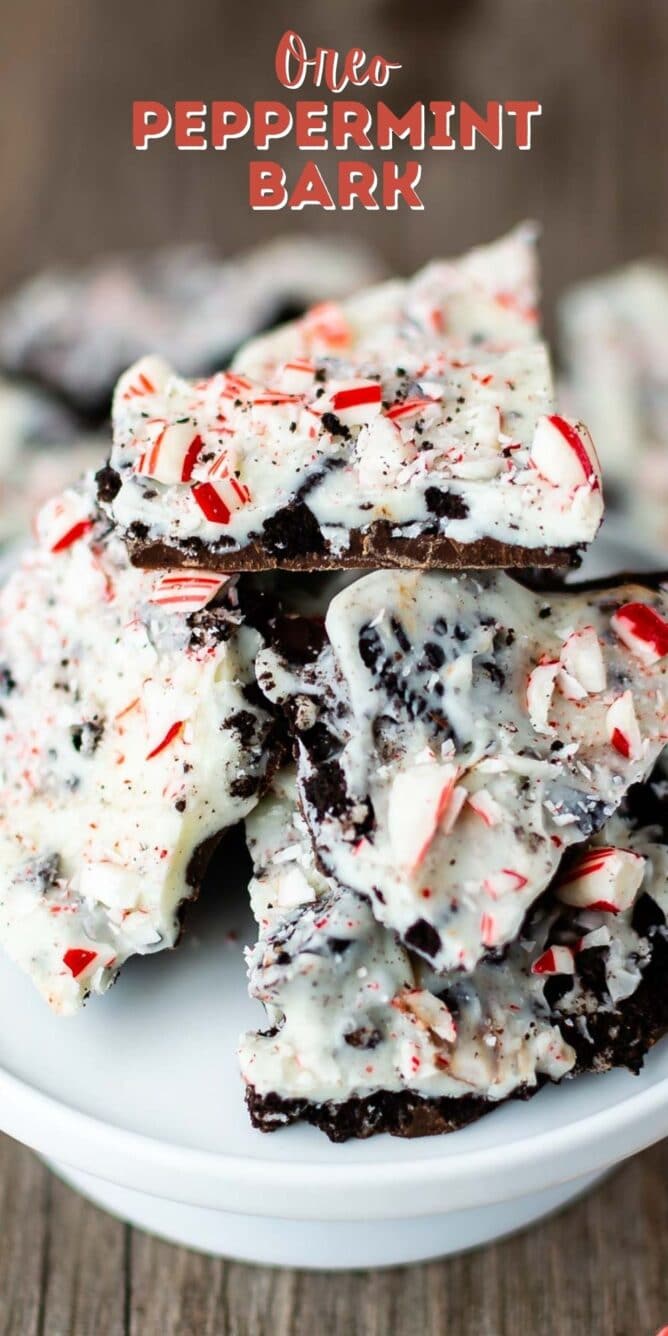Close up shot of Oreo peppermint bark pieces on a white cake stand with recipe title on top of image
