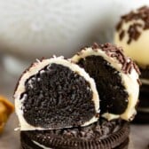 Oreo truffle cut in half sitting on top of an Oreo with more truffles in background