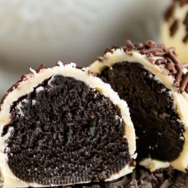 Oreo truffle cut in half sitting on top of an Oreo with recipe title on top of photo