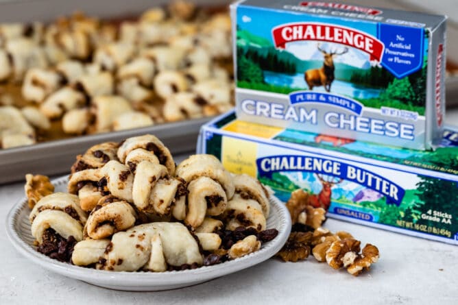 rugelach on plate with cream cheese and butter boxes behind