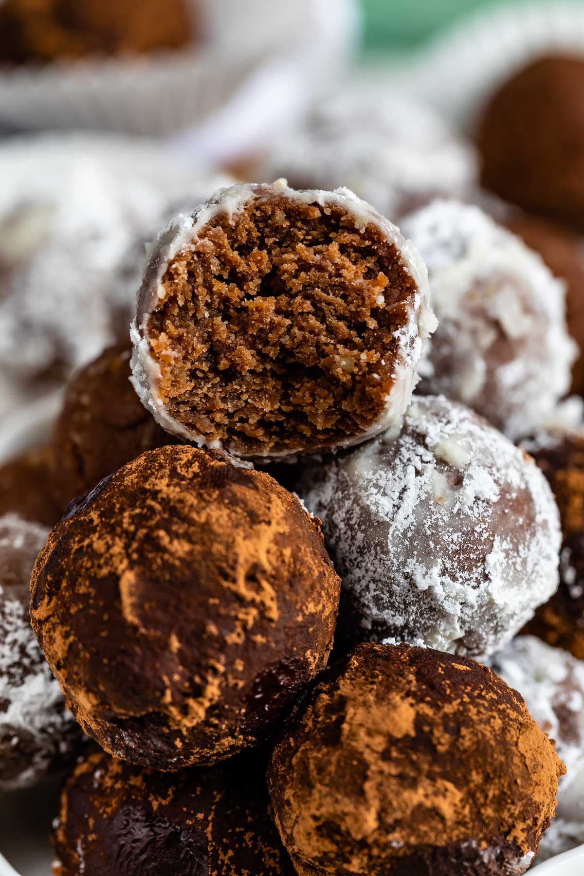 Close up shot of rum balls stacked on top of eachother with top rum ball cut in half to show inside