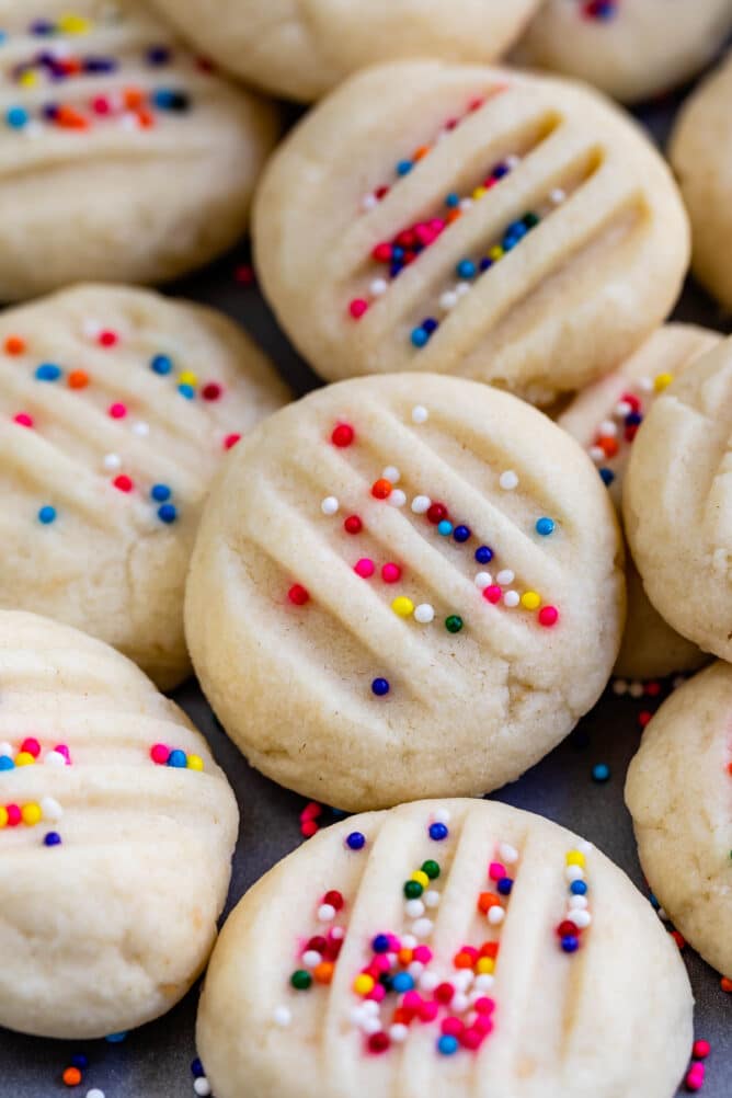 close up of mini shortbread cookies with sprinkles on them