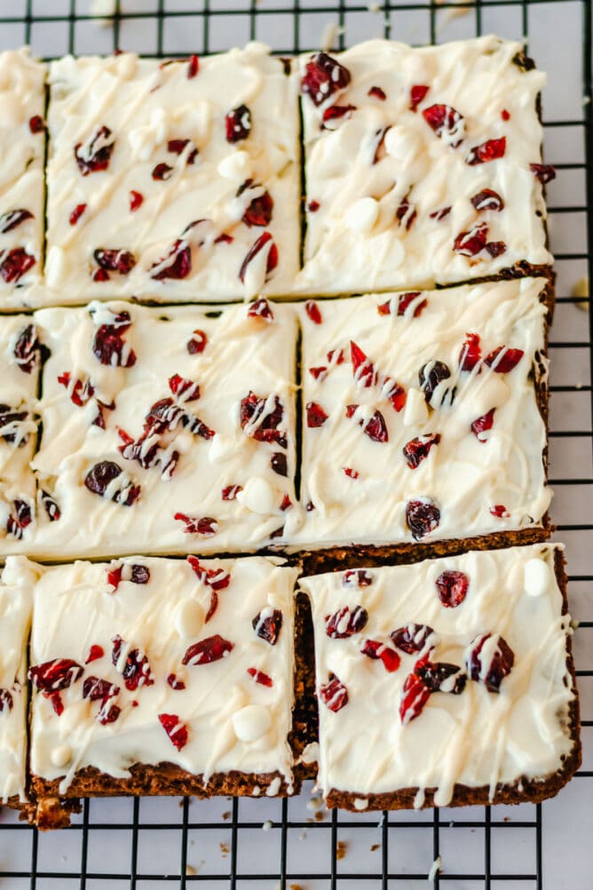 Overhead view of cranberry bliss bars on a metal cooling rack cut into squares