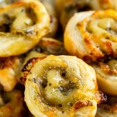 Pesto pinwheels on a white plate with recipe title on the top of image