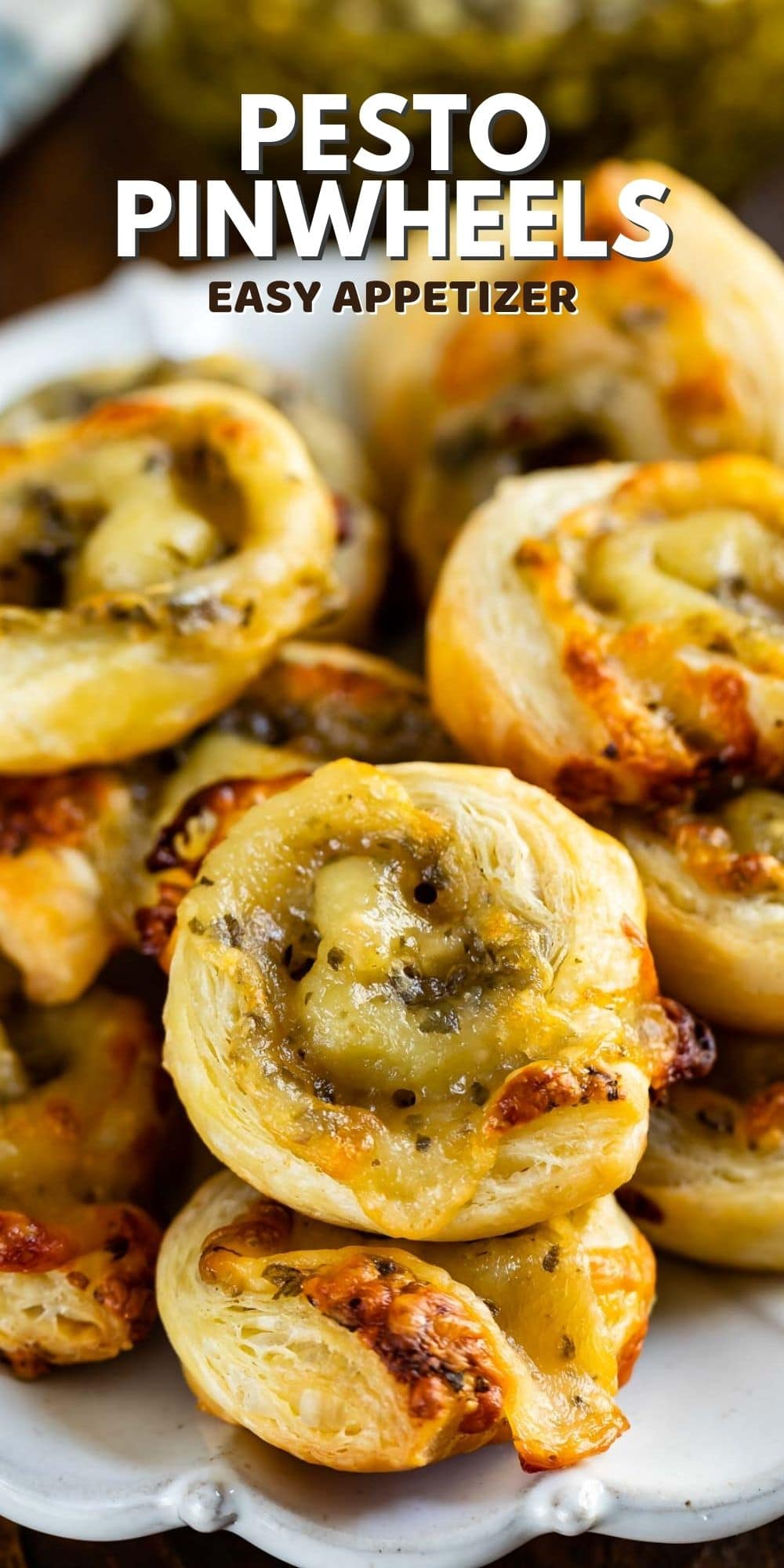 Pesto pinwheels on a white plate with recipe title on the top of image